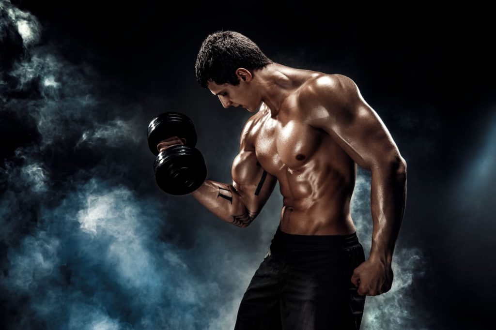 concentrated-muscular-man-doing-exercise-with-dumbbell